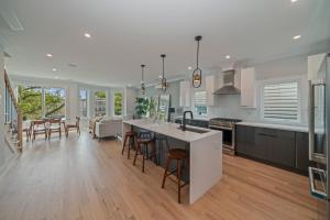 a kitchen and living room with a kitchen island and chairs at Huge 2000 sqft Luxury & Stylish Condo minutes to New York in Jersey City +15 photos