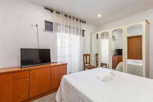 a bedroom with a bed and a flat screen tv at NEW! Castel de Paiva in Raiva