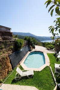 a swimming pool with two lawn chairs next to it at NEW! Castel de Paiva in Raiva