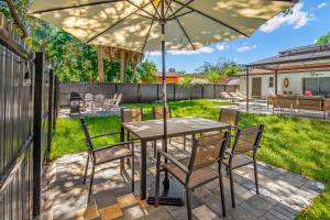 a patio with a table and chairs under an umbrella at When in Naples!!! Pool Villa-Attached, 3 miles to the Beach in Naples