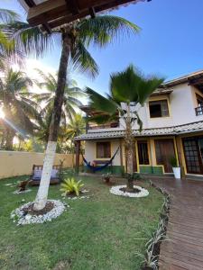 two palm trees in front of a house at Pousada Oceano Atlântico in Barra Grande