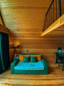 a green couch in a room with a wooden ceiling at Gold cottages Kazbegi in Kazbegi