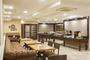 ein Restaurant mit Holztischen und einer Bar in der Unterkunft Antroyal Hotel in Antalya
