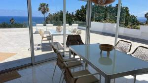 a dining room with a table and chairs on a patio at Zen Ocean View House Tenerife in Los Realejos