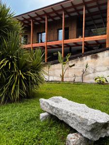 a rock sitting in the grass in front of a building at QG Quinta de Grovelas in Balança