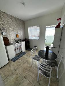 a kitchen with a table and chairs in a room at Casa Onda Azul 1 in Saquarema