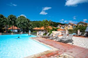 una piscina con sedie e una persona in acqua di Kay lanmou location de vacances Sainte Anne a Sainte-Anne