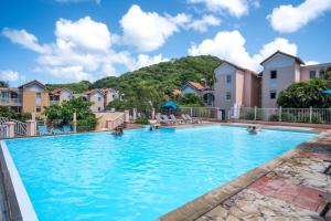 una piscina in un resort con una montagna sullo sfondo di Kay lanmou location de vacances Sainte Anne a Sainte-Anne