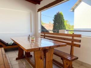 a wooden bench sitting in a room with a window at Apartmani MOSLAVINA i parking in Kutina