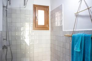 a bathroom with a shower with blue towels and a window at Domo Bangone - Sa Corte in Orosei +56 photos