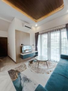 un soggiorno con un divano blu e un tavolo di Villa Kamar Tamu Maleha a Gandok