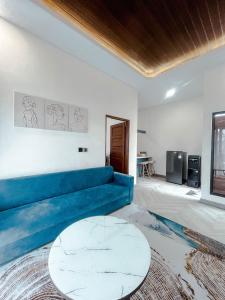 un soggiorno con un divano blu e un tavolo di Villa Kamar Tamu Maleha a Gandok