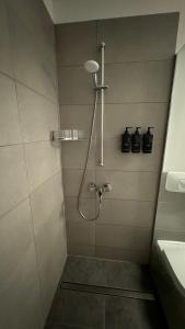 a bathroom with a shower with a shower head at Sonnige Wohnung im Zentrum mit Terrasse u Tiefgarage - Netflix & Prime in Leipzig +18 photos