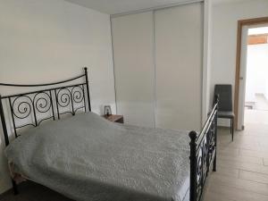 a bedroom with a bed and a chair in it at A la campagne in Montolieu