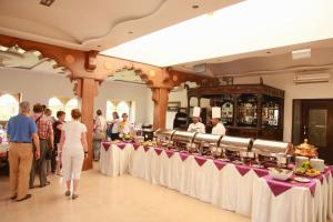 a group of people standing around a table with food at Thar Oasis Resort and Camp in Dechu
