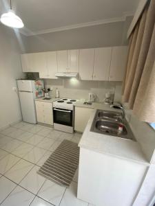 a kitchen with white cabinets and a sink at Handra Apartment Seaview in Kos +7 photos