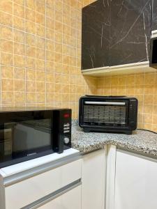 eine Mikrowelle auf einer Theke in einer Küche in der Unterkunft Diamond Madinaty New Cairo in Madinaty + 30 Fotos