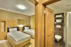 a small bedroom with two beds and a toilet at Antroyal Hotel in Antalya