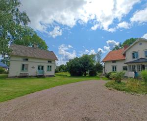 a house with a driveway in front of a yard at Lilla Backen in Hjo