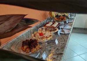 a buffet with several plates of food on a table at Pousada Cantinho do Sossego in Arraial d'Ajuda