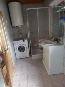 un piccolo bagno con lavatrice e lavandino di Apartment ML FREE PARKING a Loče pri Poljčanah