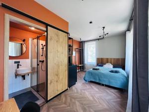 a bedroom with a bed and a sink and a mirror at Platforma2b in Šiauliai