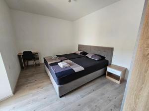 a bedroom with a bed and a table and a chair at APARTMA IVA in Koper