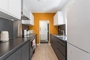 a kitchen with black and white counters and a sink at 4 Beds 3 Bath (2-ensuites) Free Parking 75Mbps in Stoke on Trent