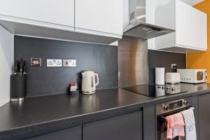 a kitchen with white cabinets and a counter top at 4 Beds 3 Bath (2-ensuites) Free Parking 75Mbps in Stoke on Trent +29 photos