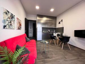 Una sala de estar con un sofá rojo y una cocina. en Vake apartment, en Tiflis