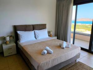 Apollonia Elounda View Villa في إيلوندا: غرفة نوم بها سرير مع مناشف عليه