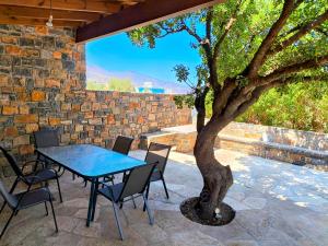 Apollonia Elounda View Villa في إيلوندا: طاولة وكراسي وشجرة على الفناء +67 صورة
