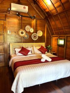 a large bed in a room with wooden walls at Langkawi Signature Resort in Pantai Cenang