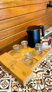 a wooden tray with glasses and a pot on a table at Langkawi Signature Resort in Pantai Cenang