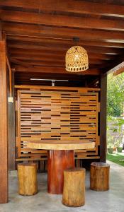 a wooden table with three wooden stools under a pavilion at Langkawi Signature Resort in Pantai Cenang