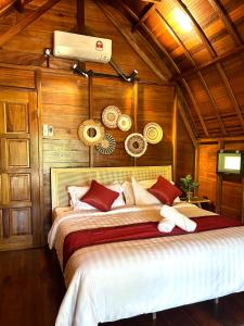 a bedroom with a large bed with wooden walls at Langkawi Signature Resort in Pantai Cenang