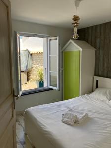 a bedroom with a bed with a green door and a window at Très belle villa, 4 chambres, piscine et jacuzzi in Rivedoux-Plage +18 photos