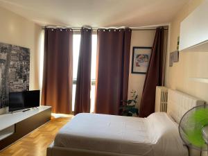 a bedroom with a bed and a window with curtains at Tyche Suite Luxury in Lecce