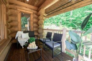 a porch of a log cabin with chairs and a table at Chalet Chic Rustique & SPA - Tremblant in Lac-Superieur