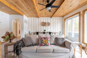 un soggiorno con un divano e un ventilatore a soffitto di Casa Olej Unforgettable getaway in Tremblant & SPA a Saint-Rémi-dʼAmherst