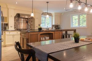 eine große Küche mit Tisch und Esszimmer in der Unterkunft Eko Eau Bonheur in Saint Adolphe D'Howard + 36 Fotos