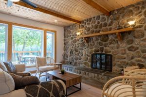 Una sala de estar con una pared de piedra con chimenea. en Casa Olej Unforgettable getaway in Tremblant & SPA, en Saint-Rémi-dʼAmherst