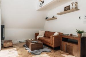a living room with a couch and a table at Kartalla - the A frame experience in Tremblant in Saint-Rémi-dʼAmherst