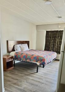 Un dormitorio con una cama y una mesa y una ventana. en Budget Inn, en Jasper