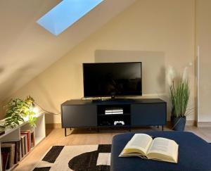 a living room with a tv and a book at La Ventana y el Ciervu in Arenas de Cabrales