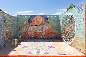 丝兰谷Modern Mosaics- Joshua Tree Chef Home On Hill Spa的墙上有马赛克,有桌子和凳子