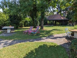 three chairs and a picnic table in a park at Maison de charme au bord du lac Léman in Anthy +29 photos