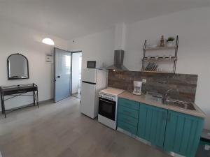 a kitchen with blue cabinets and a white refrigerator at ANGIRA - Koroni Apartments in Koroni +47 photos