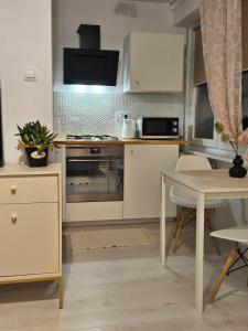 a kitchen with white cabinets and a table at Dworcowa przy basenie in Olsztyn