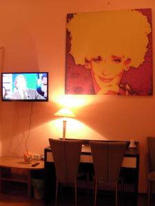 a room with a table with chairs and a tv on the wall at Affittacamere Alla Stazione in Trieste